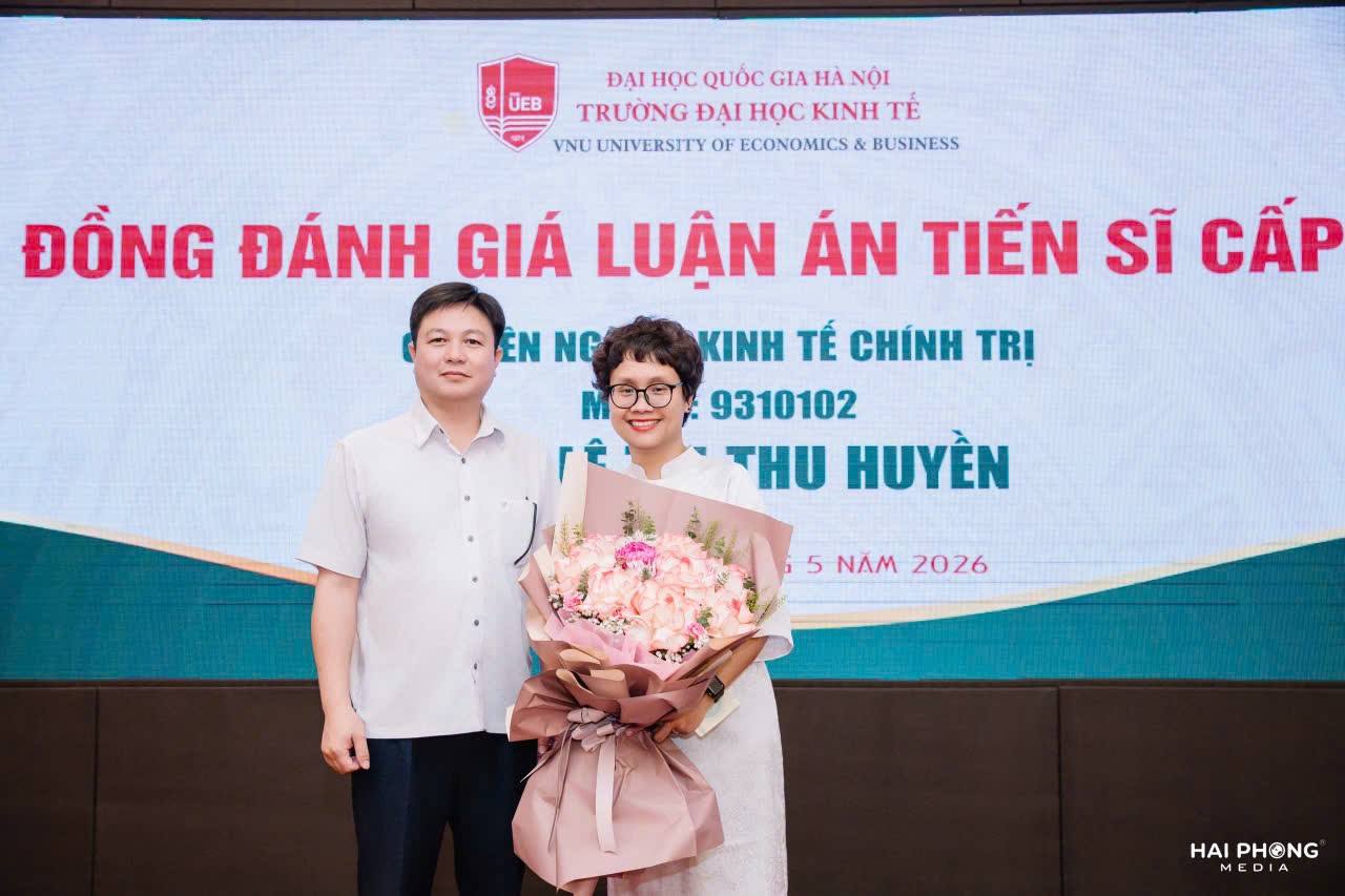 TS. Nguyễn Quang Hợp - Phó Hiệu trưởng Trường Đại học Kinh tế và QTKD tặng hoa chúc mừng Tân Tiến sĩ Lê Thị Thu Huyền